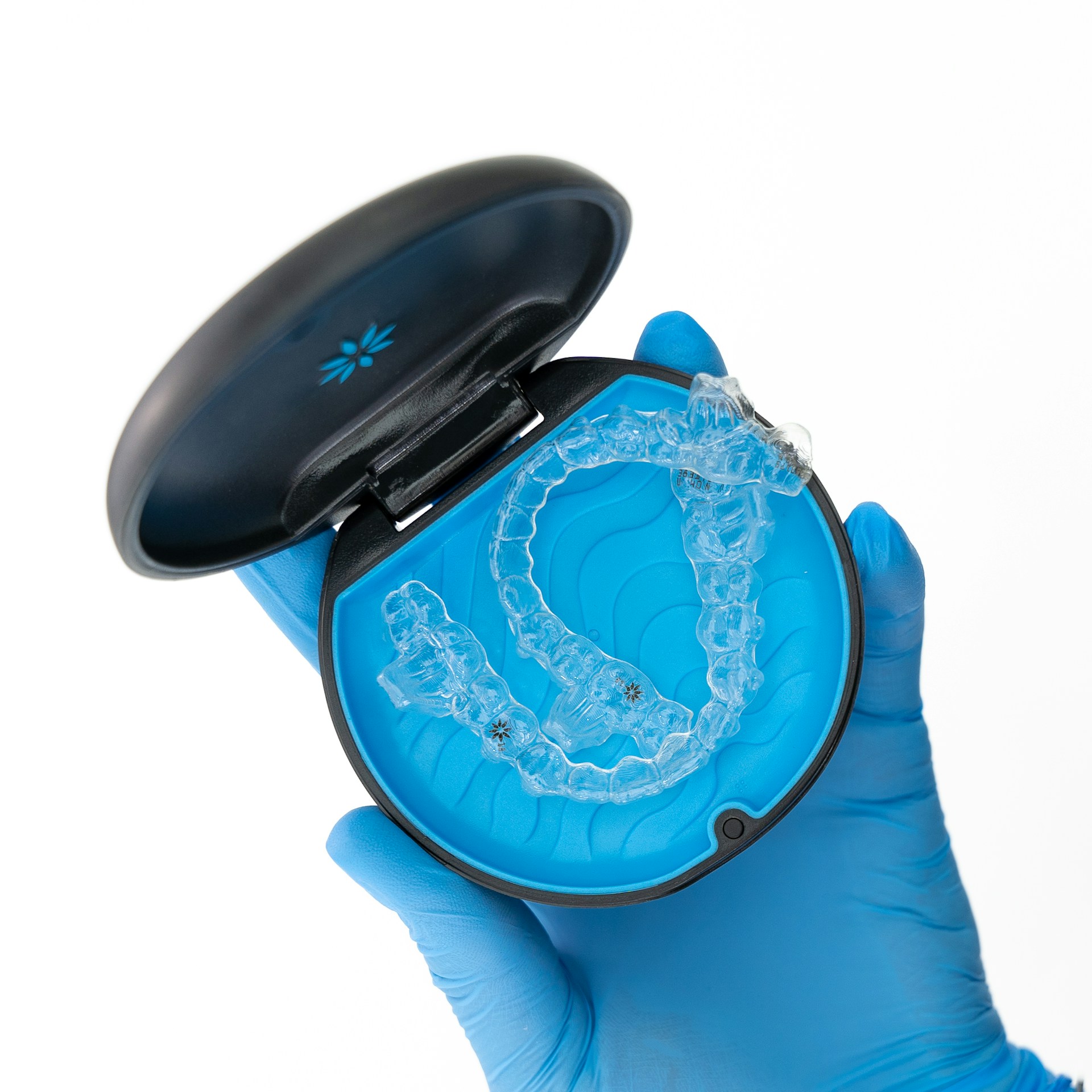 A person in blue gloves holding a plastic object photo