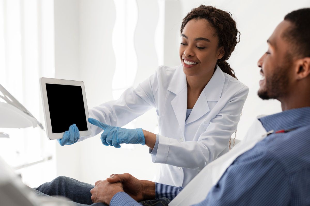 Dentist doctor pointing at empty digital tablet screen