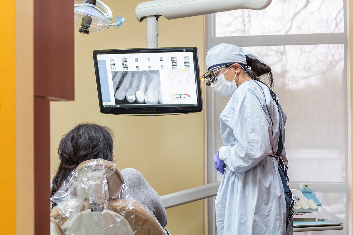 Dental team reviewing digital x-ray with patient in treatment chair